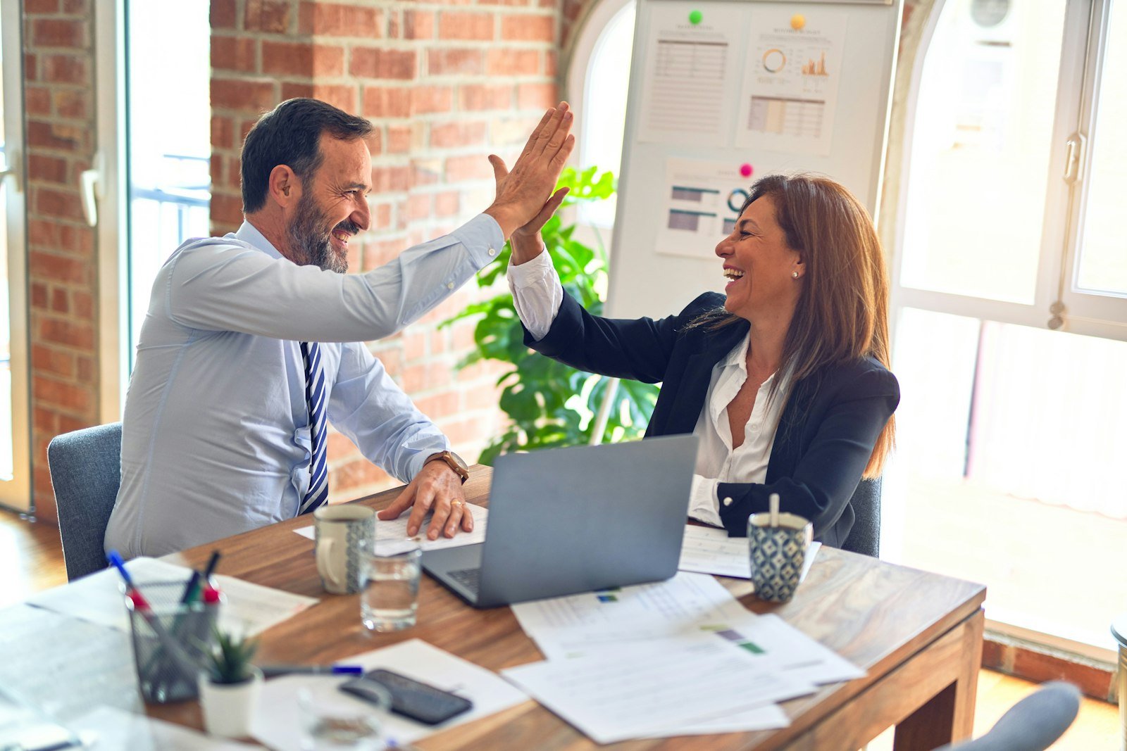 Two professionals celebrating a successful HR project outcome